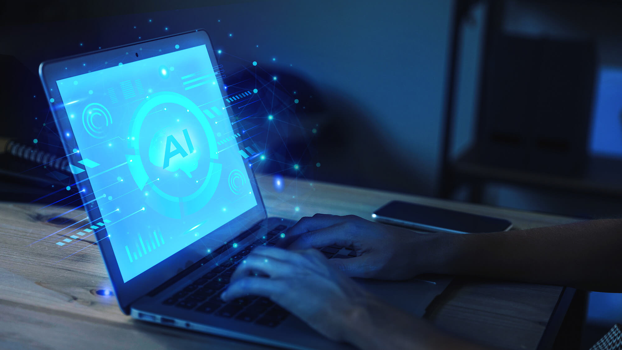 A person typing on a laptop with a glowing screen displaying "AI" and digital graphics in a dimly lit environment.