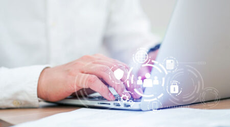 Person typing on a laptop with digital icons representing cloud computing and data sharing overlayed.