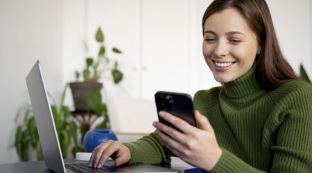 smiling customer looking at phone due to benefits of self service portal.