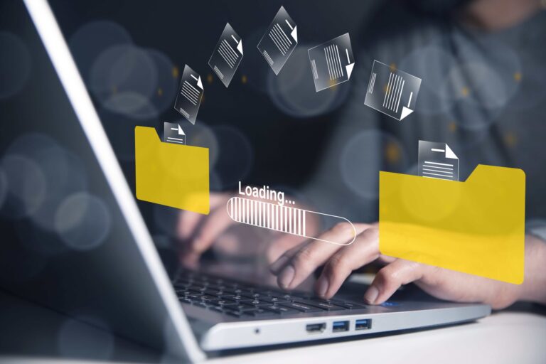 Digital content moving from one folder to another overlayed on person typing on laptop.