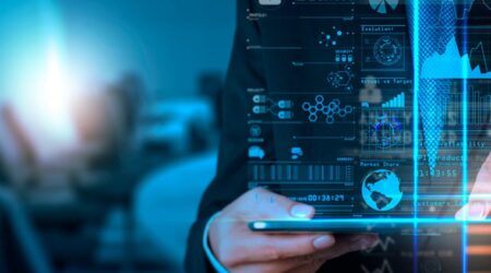 Businessman analyzing digital data hologram with graphs and analytics in a futuristic office setting.