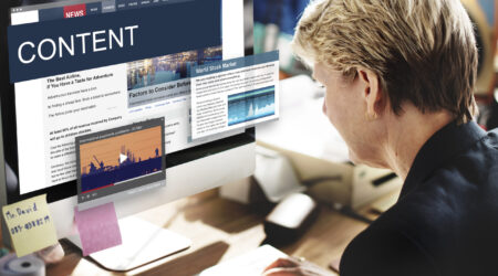 A person working on a computer displaying a website with the word "CONTENT" and various articles, alongside a video thumbnail.