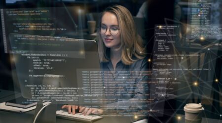 woman on computer surrounded by code tags.