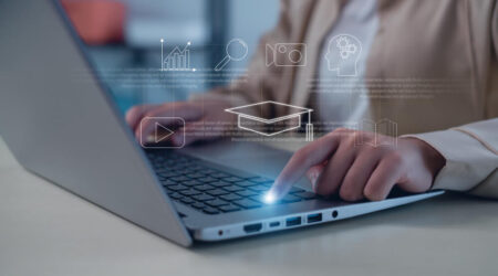 Digital icons of metrics, content, and learning systems over a person typing on laptop.