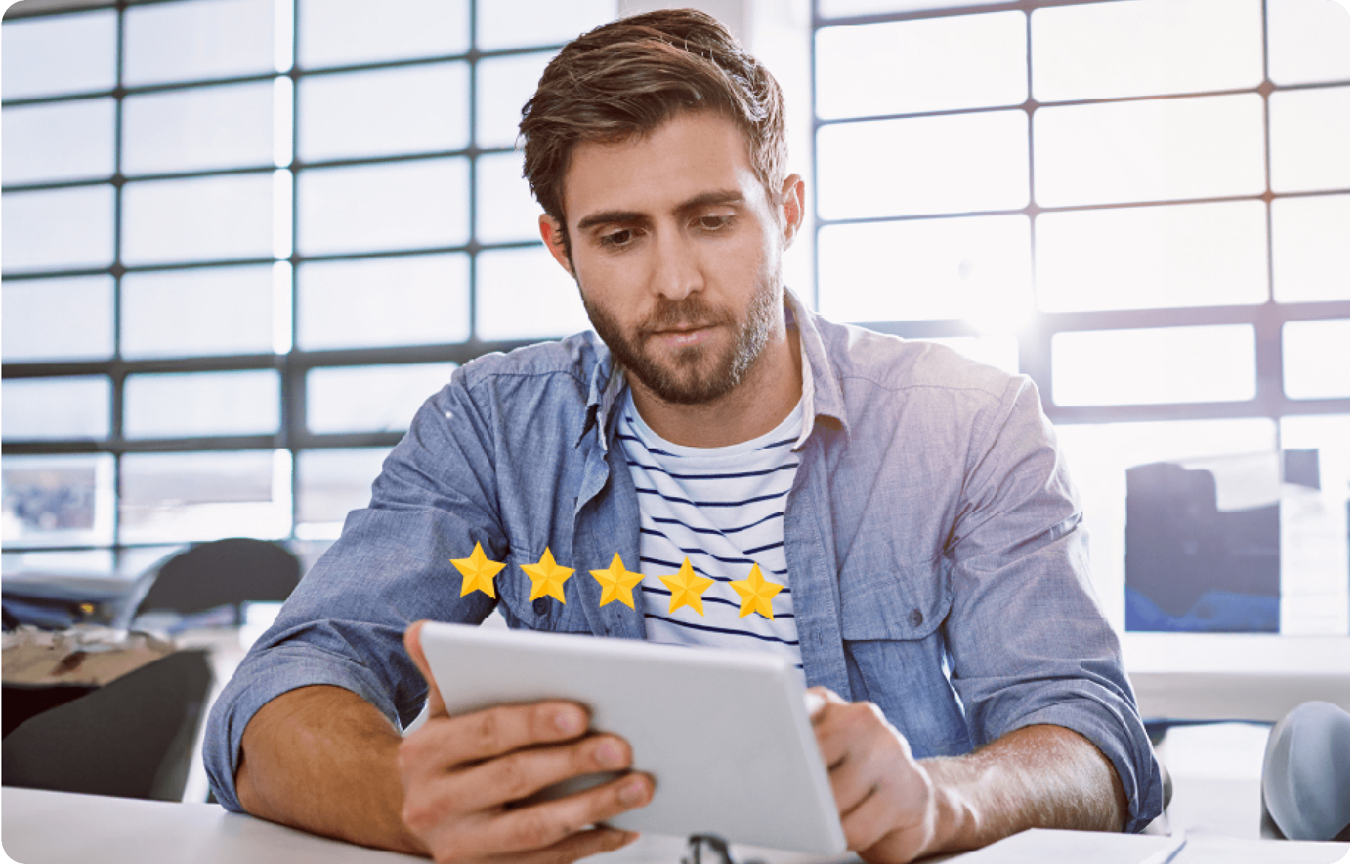 A man sits at a table in a bright room, looking at a tablet. Five yellow stars indicating a top rating appear in front of the tablet screen.