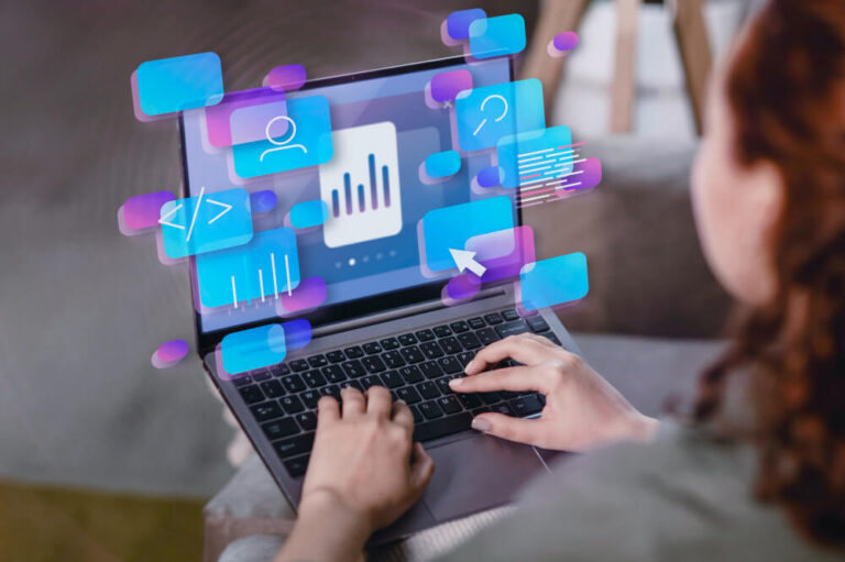 Woman on her laptop with digital interfaces and symbols over the screen.