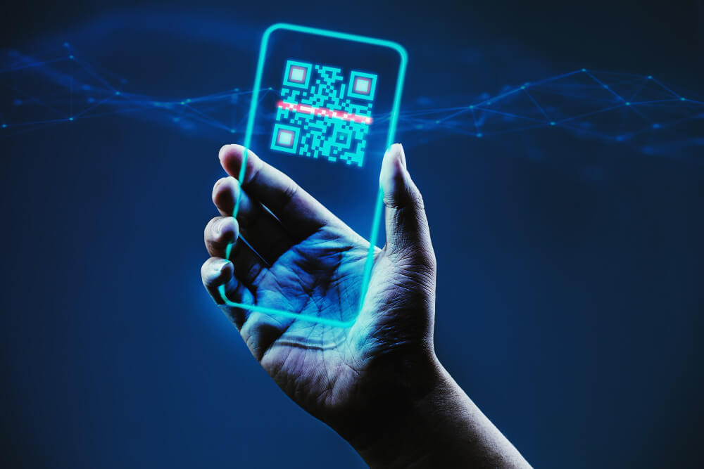 Hand holding the digital outline of a mobile phone scanning a QR code.