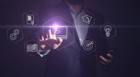 Person in a suit touching digital overlay showing with a video icon.