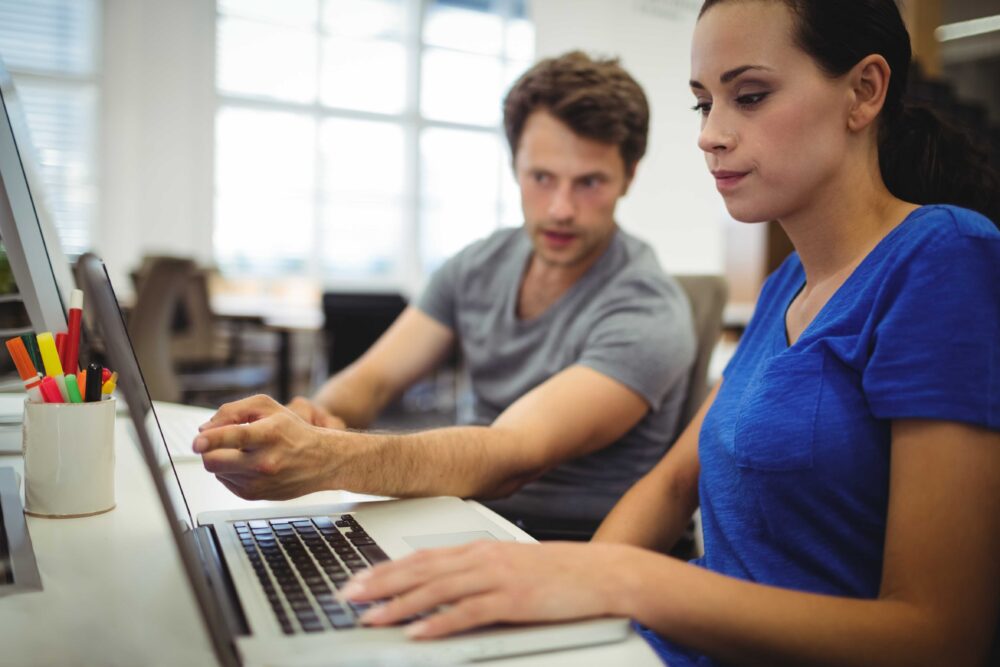 Business executives discussing over laptop
