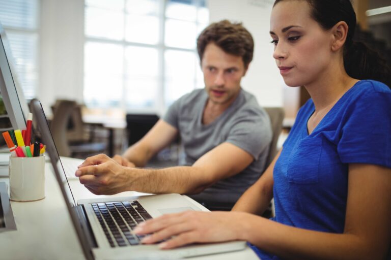 Business executives discussing over laptop
