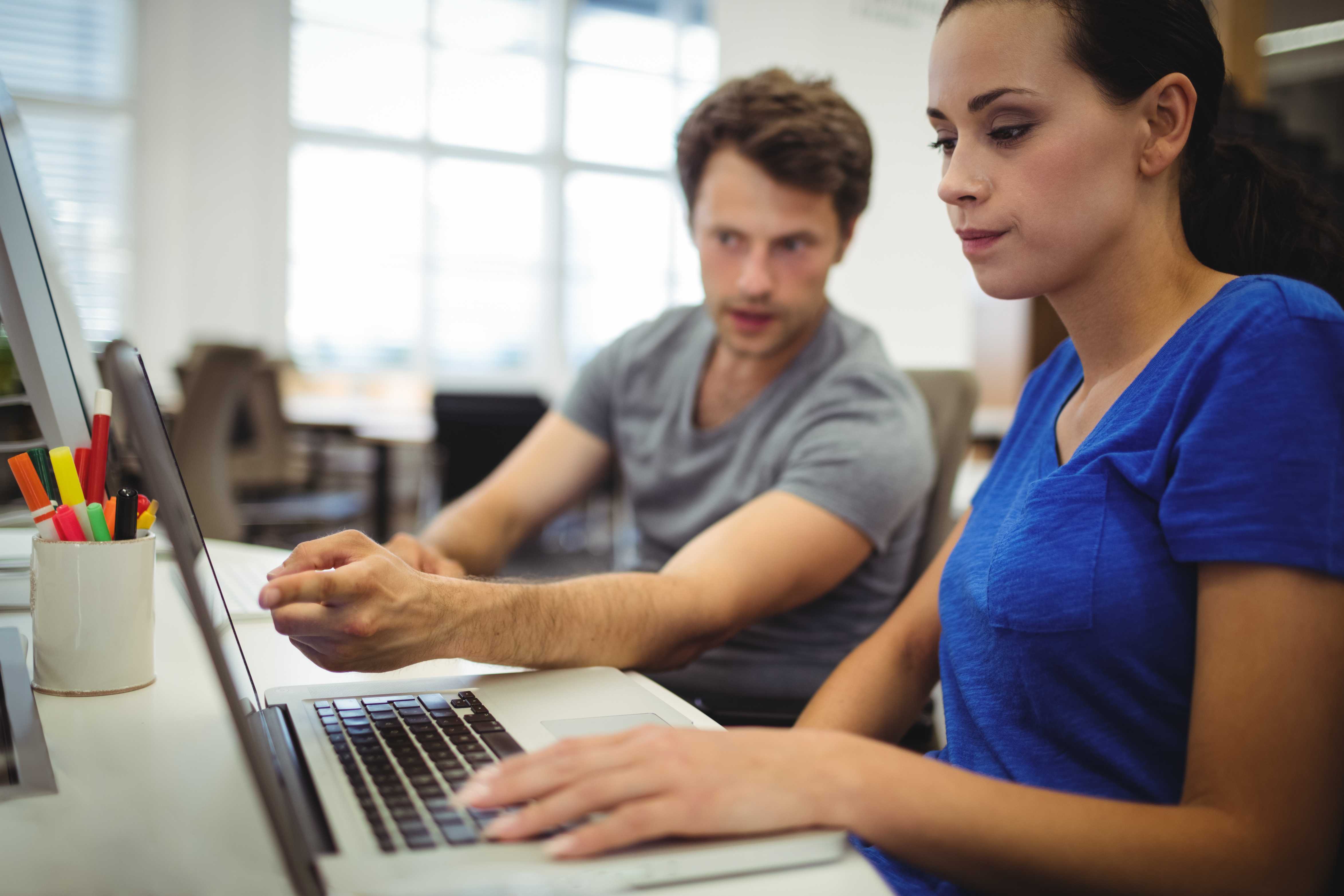 Business executives discussing over laptop