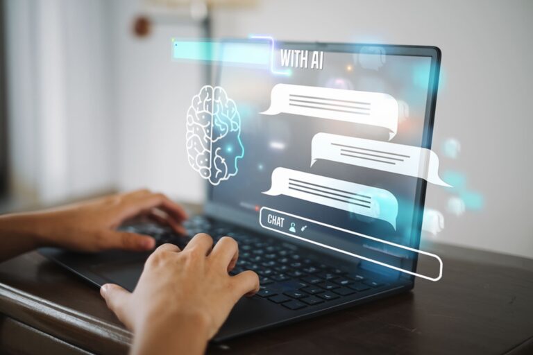 Person typing on a laptop with virtual chat bubbles and a brain icon representing artificial intelligence displayed above the keyboard.