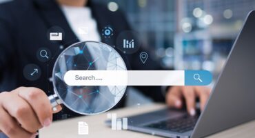 different data icons around search bar and person holding magnifying glass.