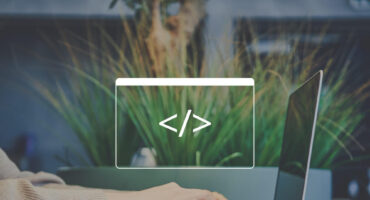 A person typing on a laptop with a code symbol overlay and greenery in the background.