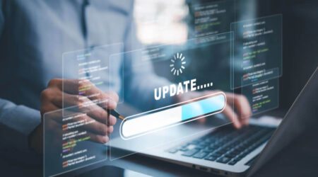 Person using laptop with digital 'UPDATE' progress bar on transparent screen, futuristic vibe.