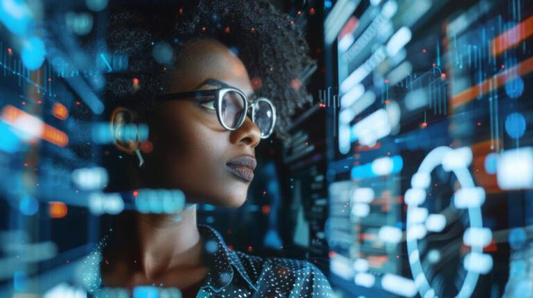 Woman with glasses looking into digital data center screens.